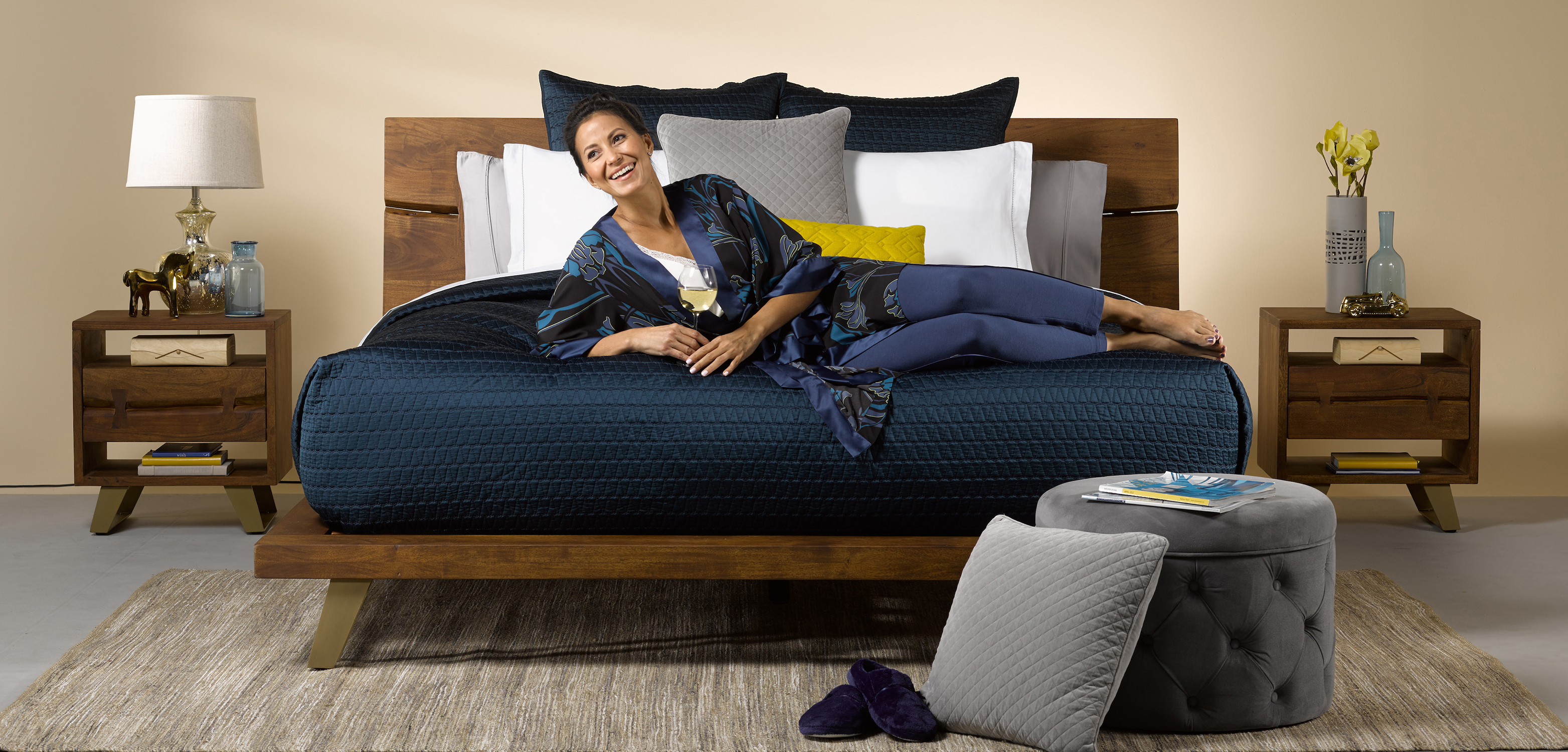 model doing a photo shoot while laying on a bed that has been style by a photo stylist