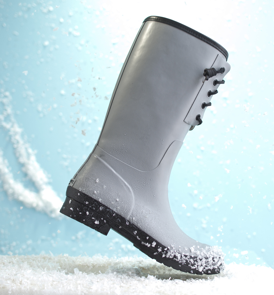 A blue rain boot that has been style by a professional footwear stylist with a snowy background