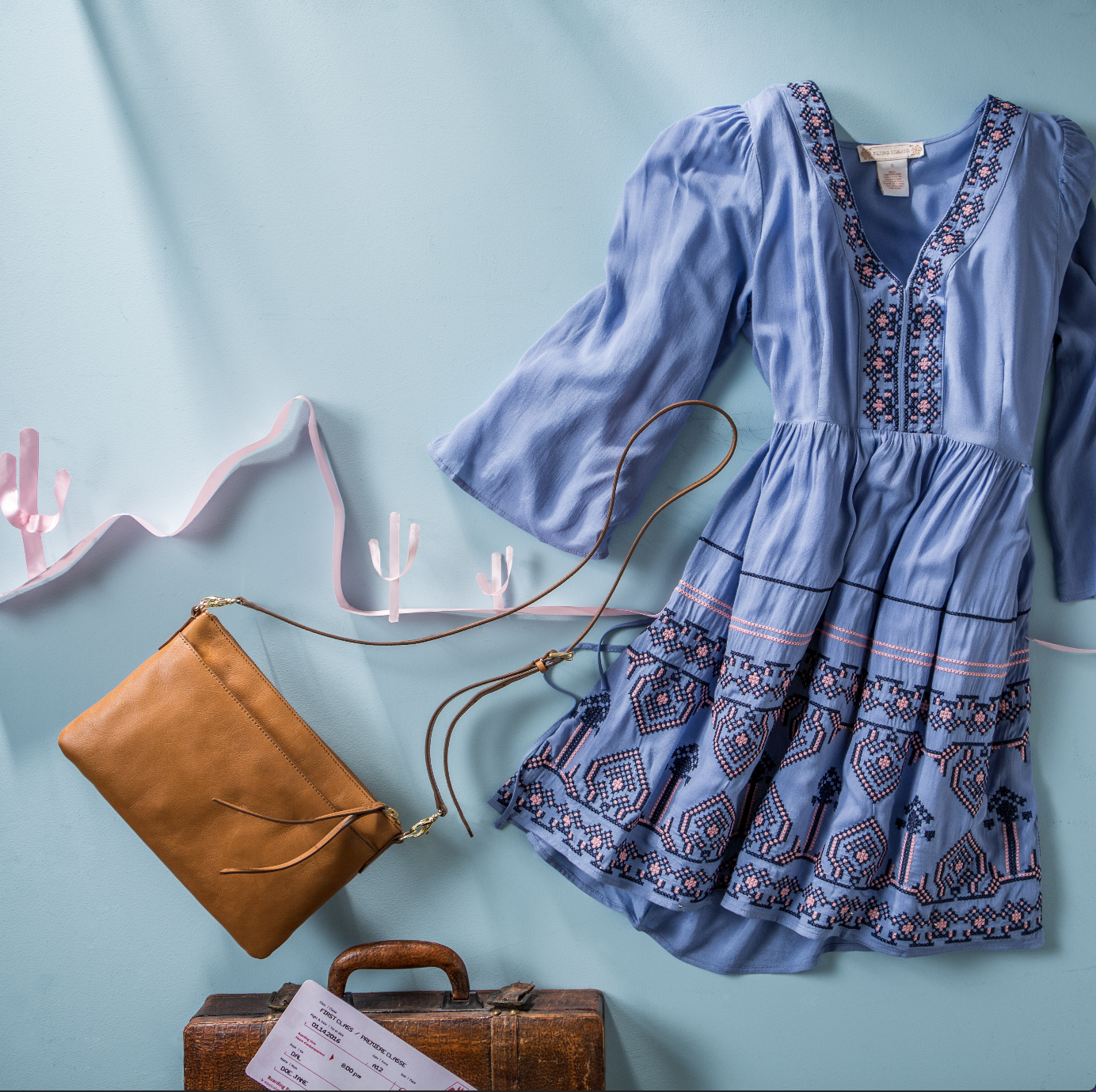 Women's dress and bags professionally displayed by an apparel stylist