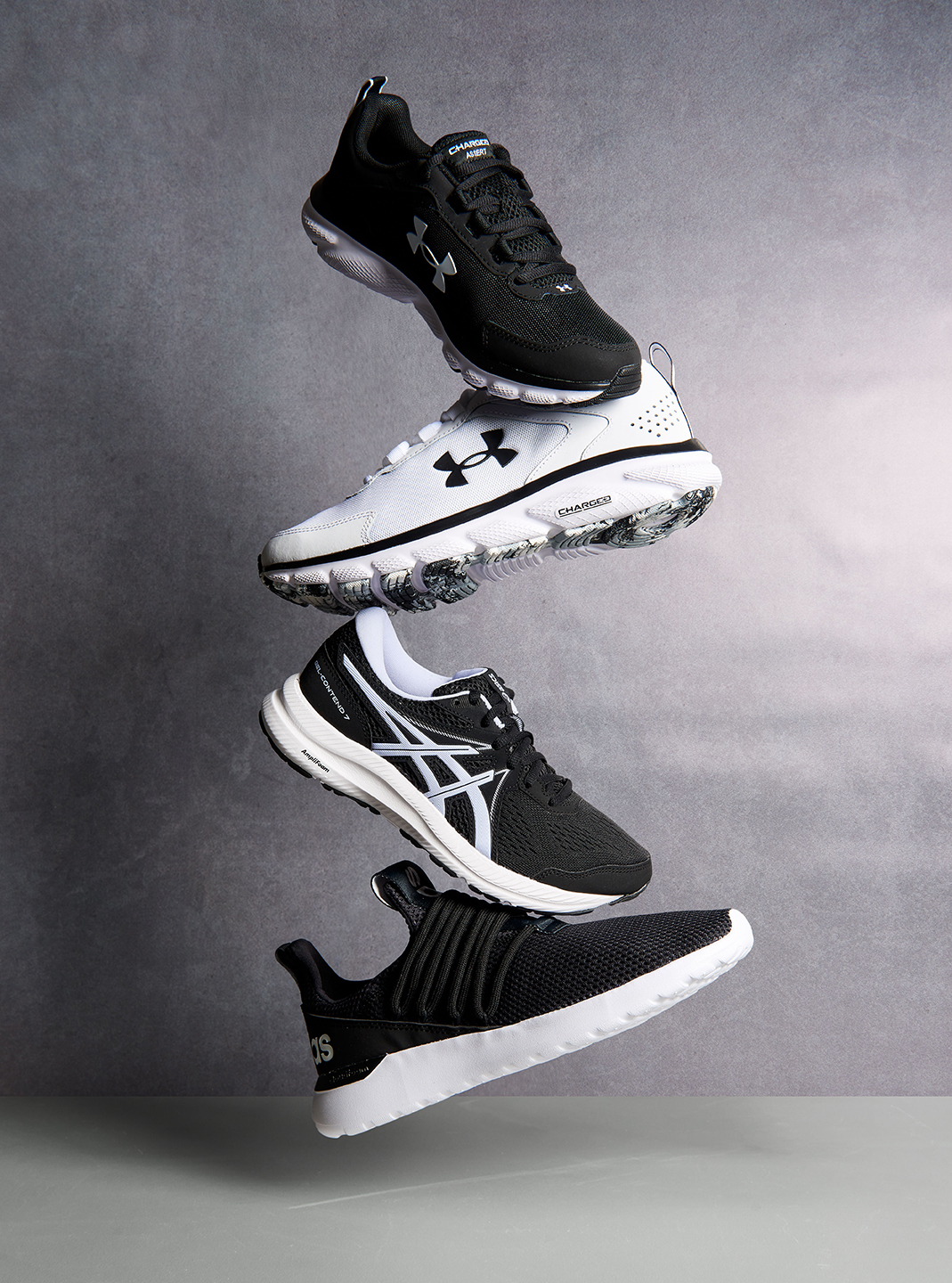 Under Armour sneakers hanging from a light that have been styled by a footwear photo stylist