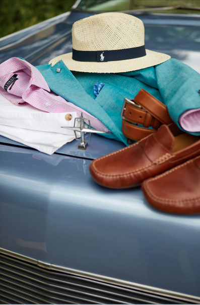 Mens formal wear outfit professionally displayed on the hood of a car by an apparel stylist